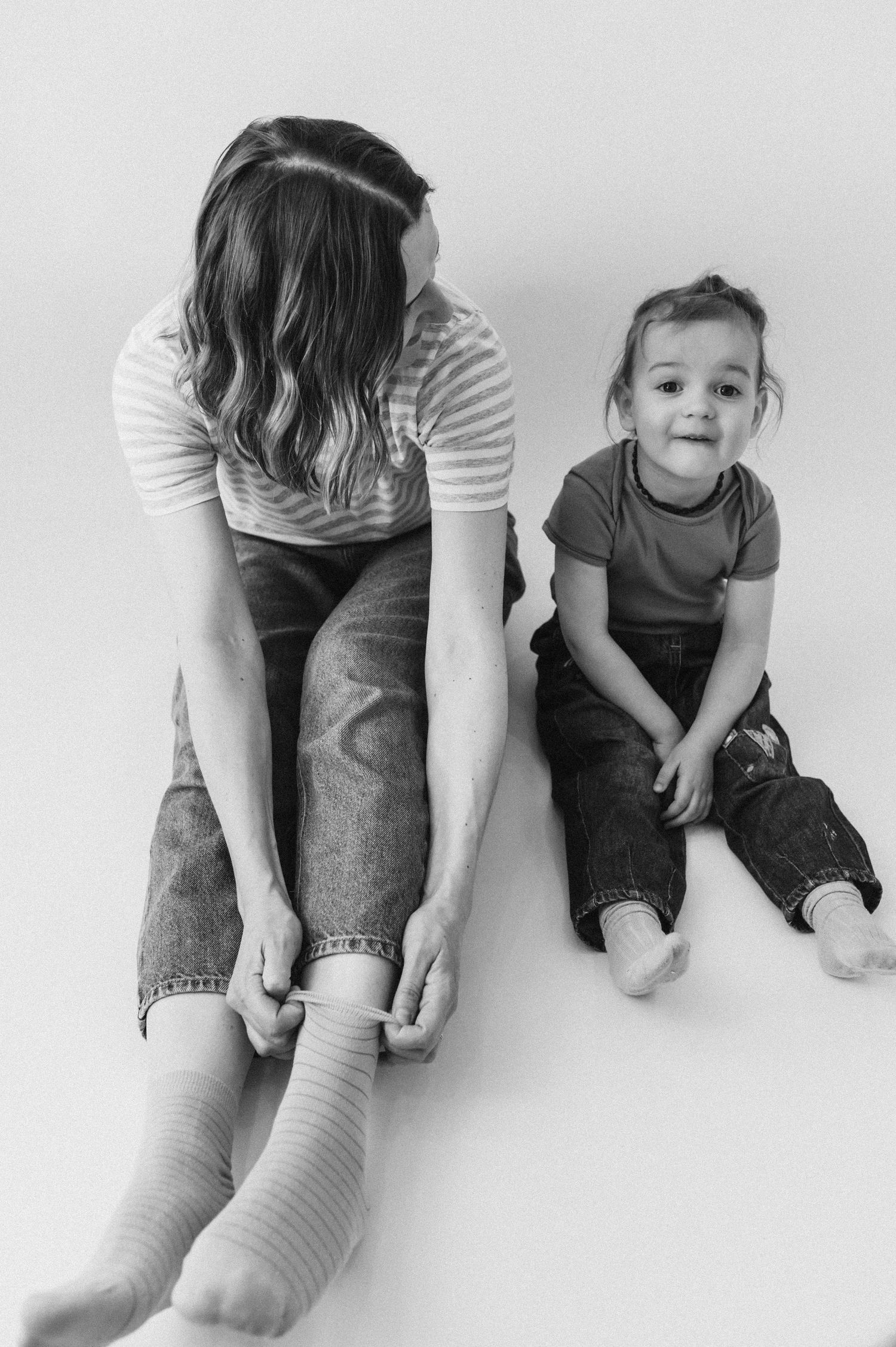 Black and white series showing parent and child sitting together on floor.