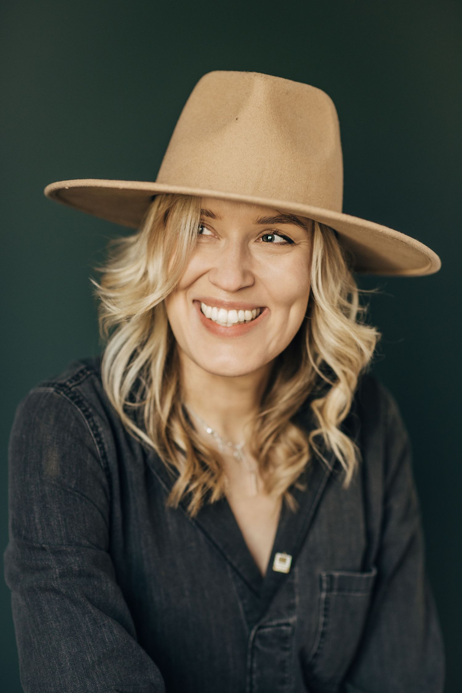 Fashion portraits with tan fedora hat and black denim jacket against dark green background.