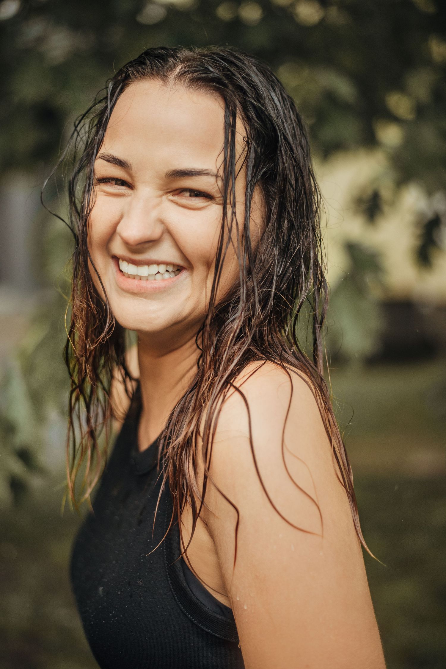 Joyful summer portrait with wet hair and natural lighting outdoors.