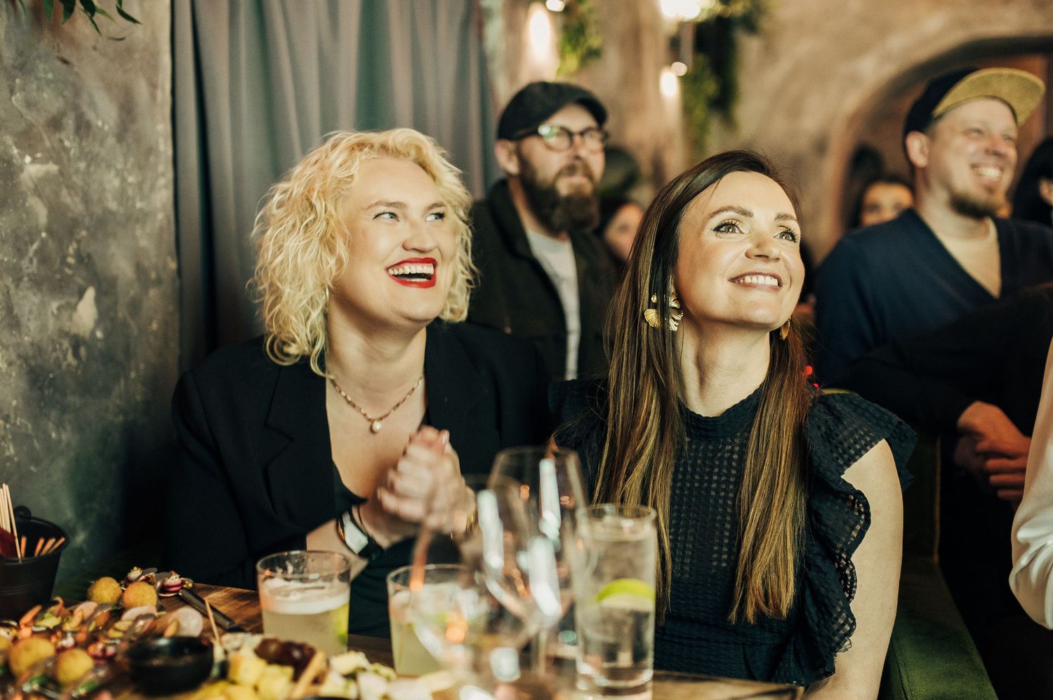 Guests enjoying dinner and conversation at an elegant evening event.