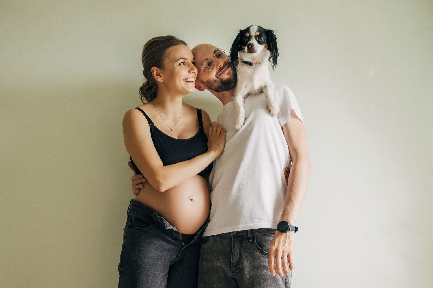 Couple embracing with their pet dog in a tender indoor moment.