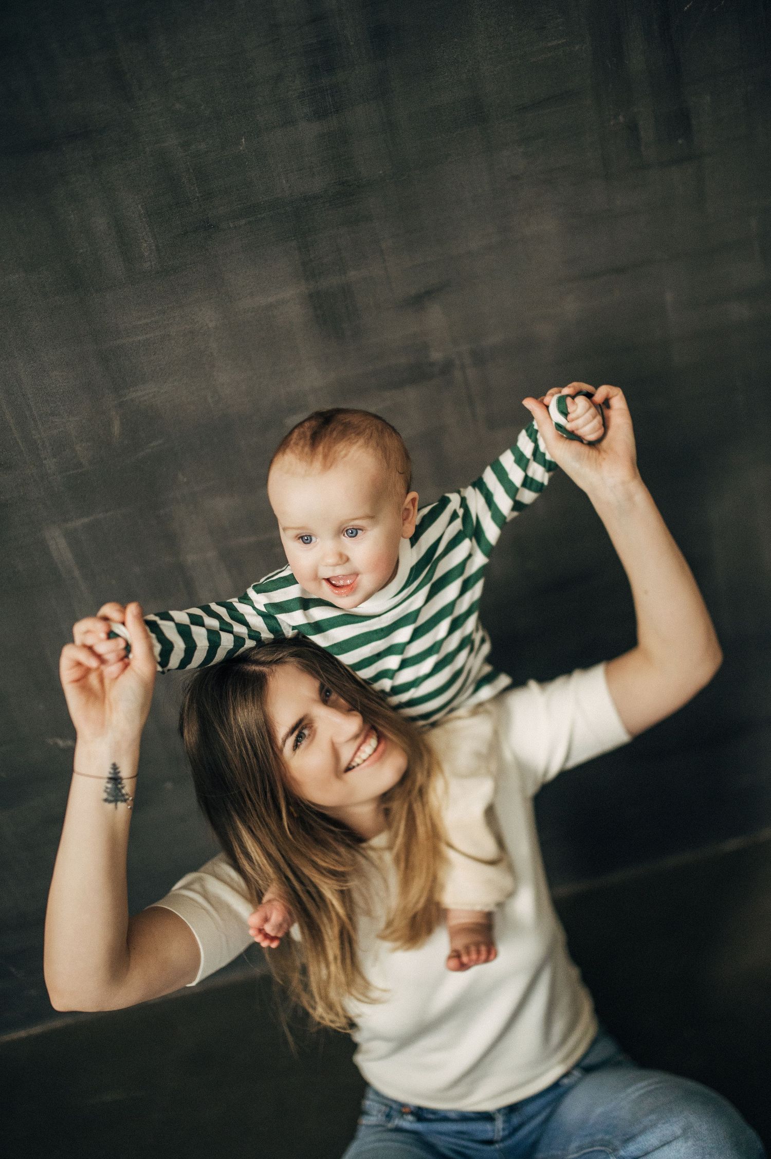 Playful sequence of parent-child interaction against dark background with striped clothing.