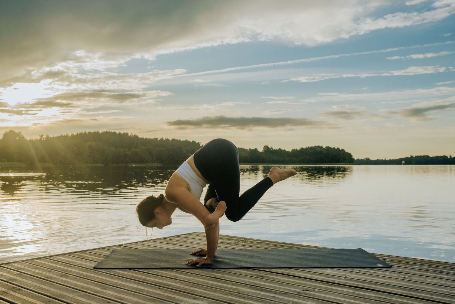 Sequence of yoga postures performed on a dock with stunning lake and sky views.