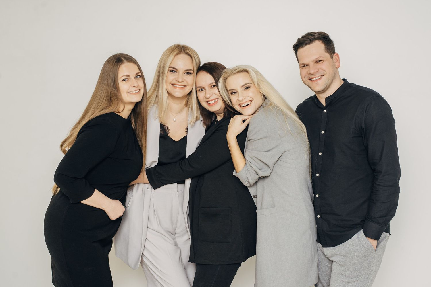 Studio portrait series featuring group in coordinated black and grey outfits.