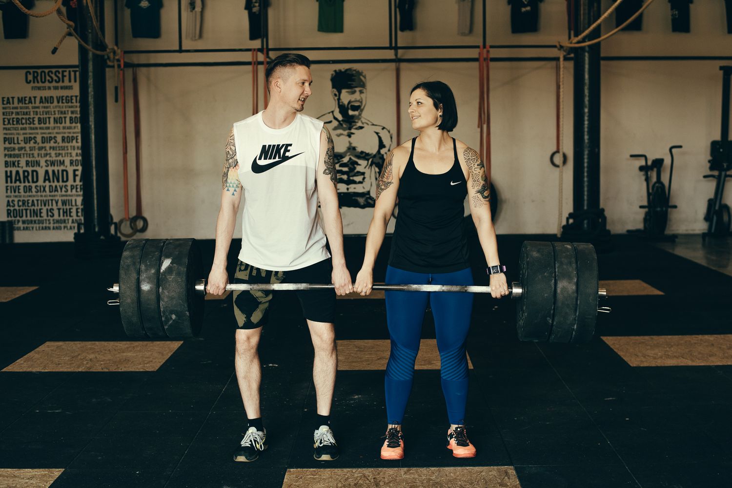 Group workout session with barbells in a minimalist gym space.