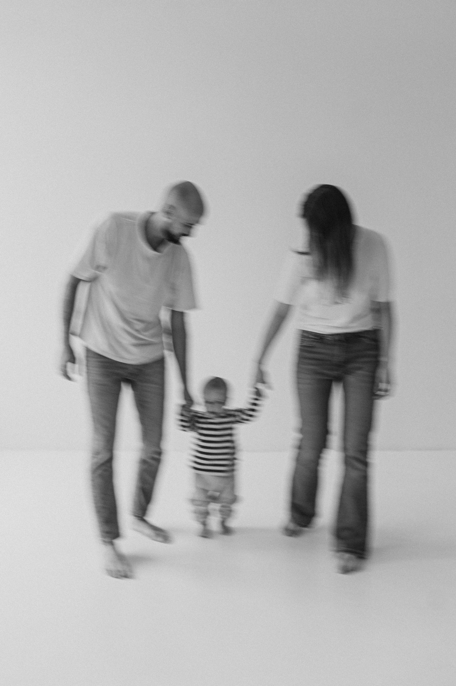 Artistic black and white sequence showing walking figures against white background.