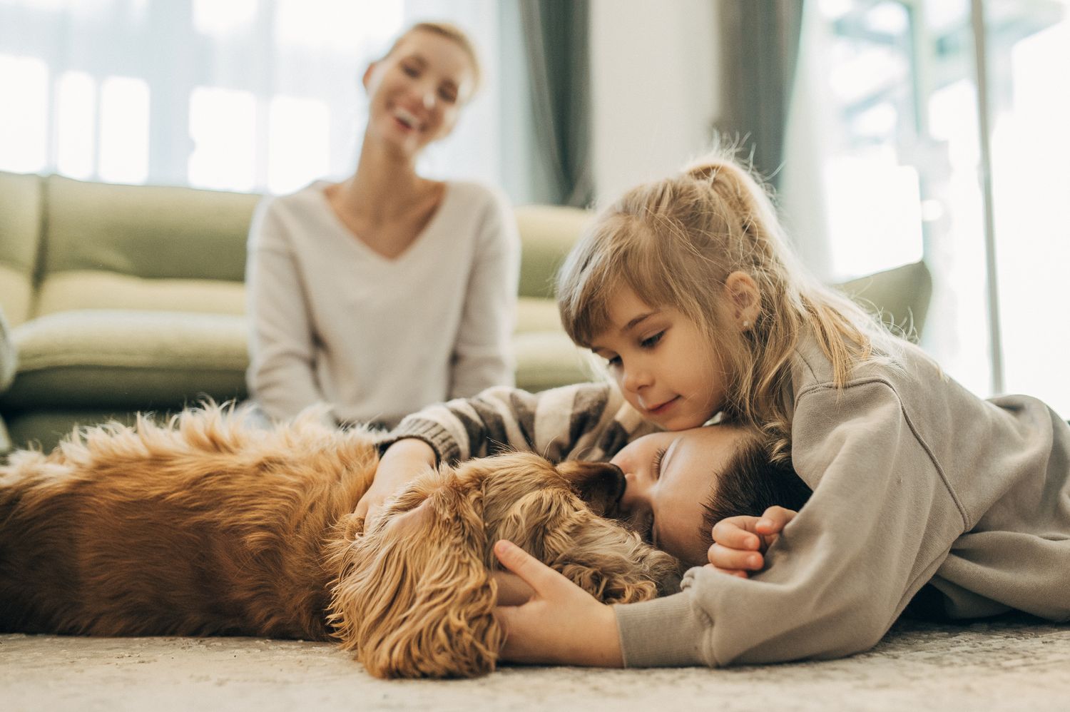 Relaxing moments captured with family and dog on floor in sunlit room.