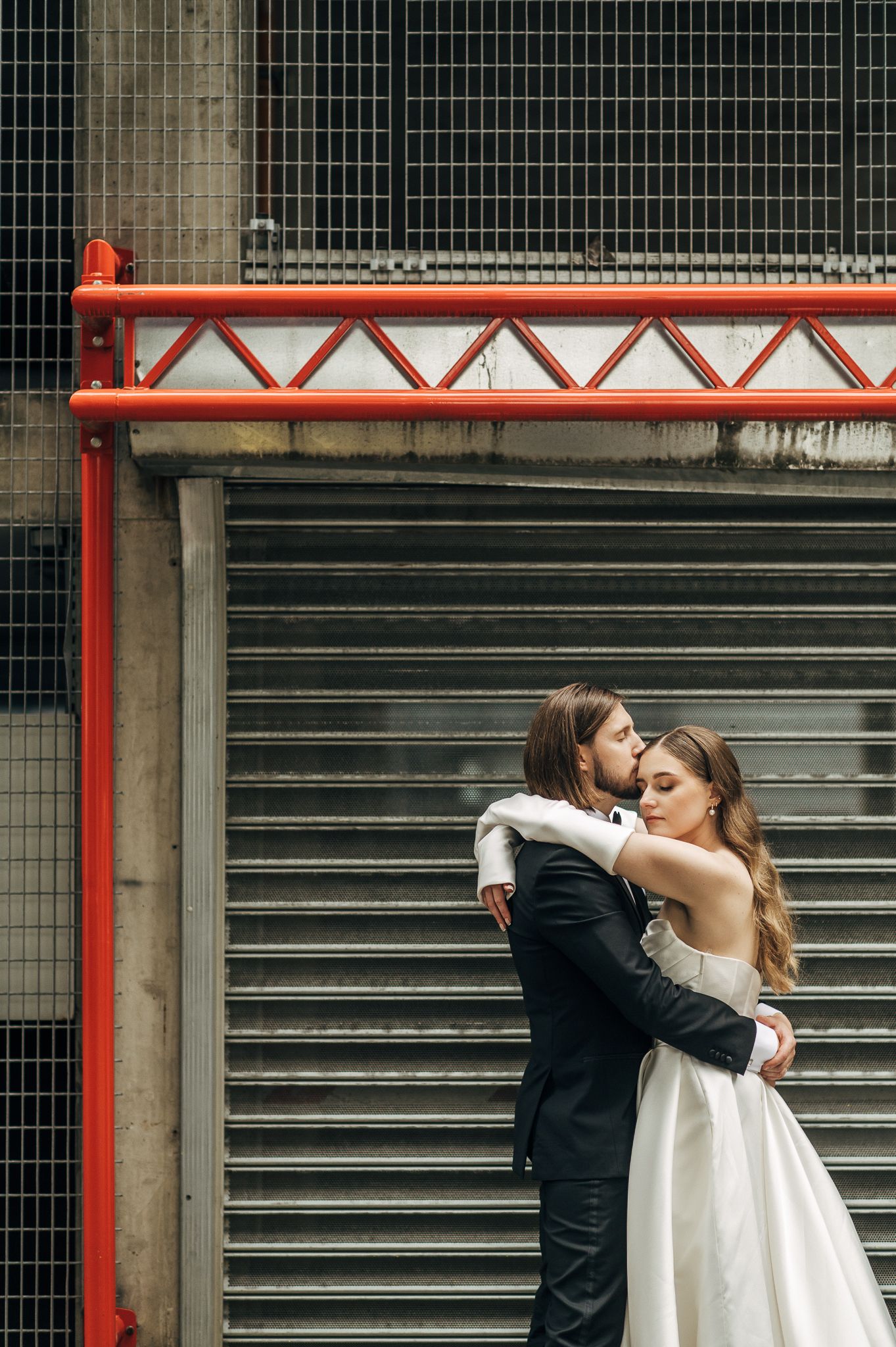 A romantic wedding photo series in front of a metal shutter backdrop.