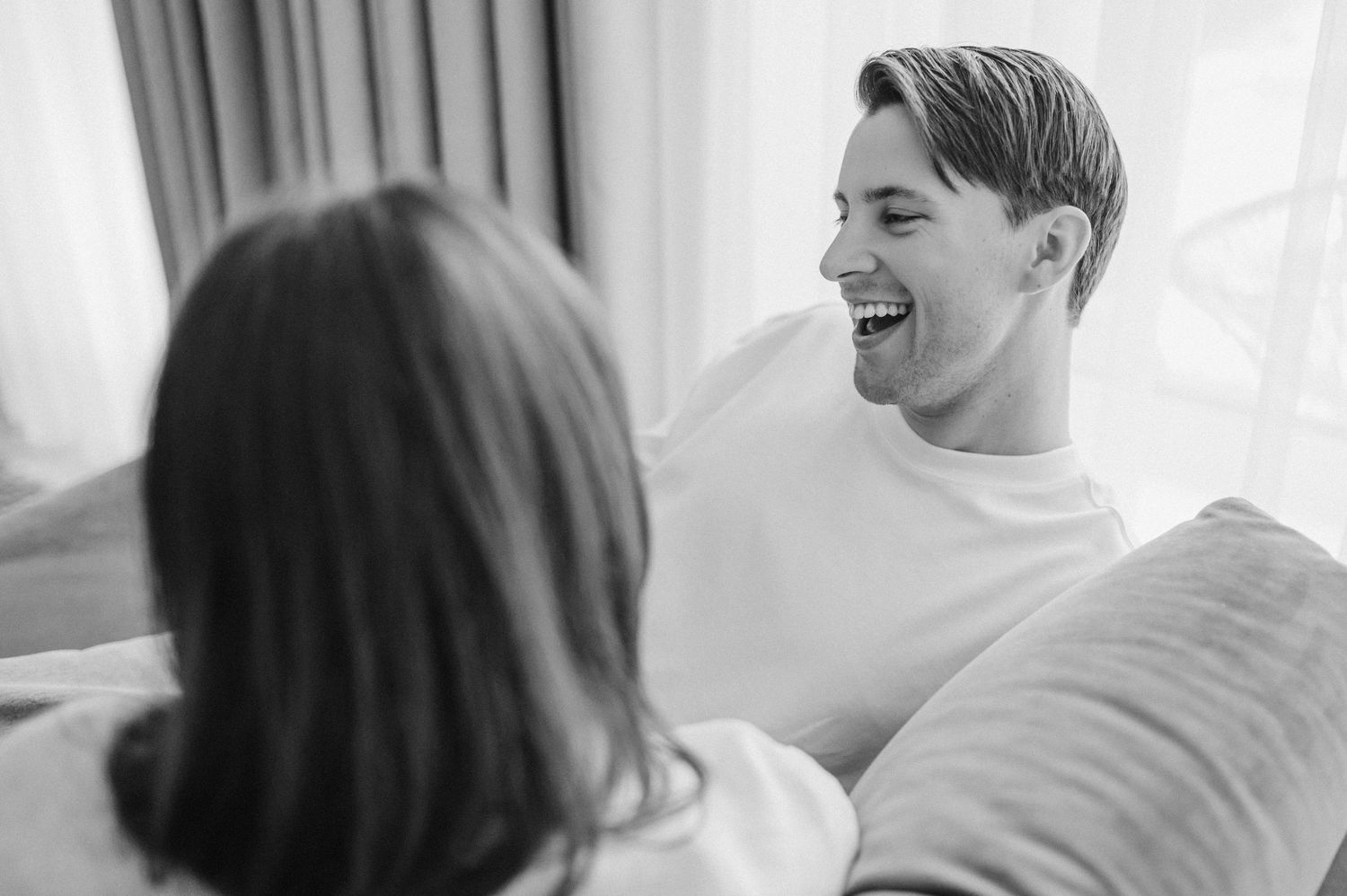 Candid moments of laughter and joy captured in bright interior setting.