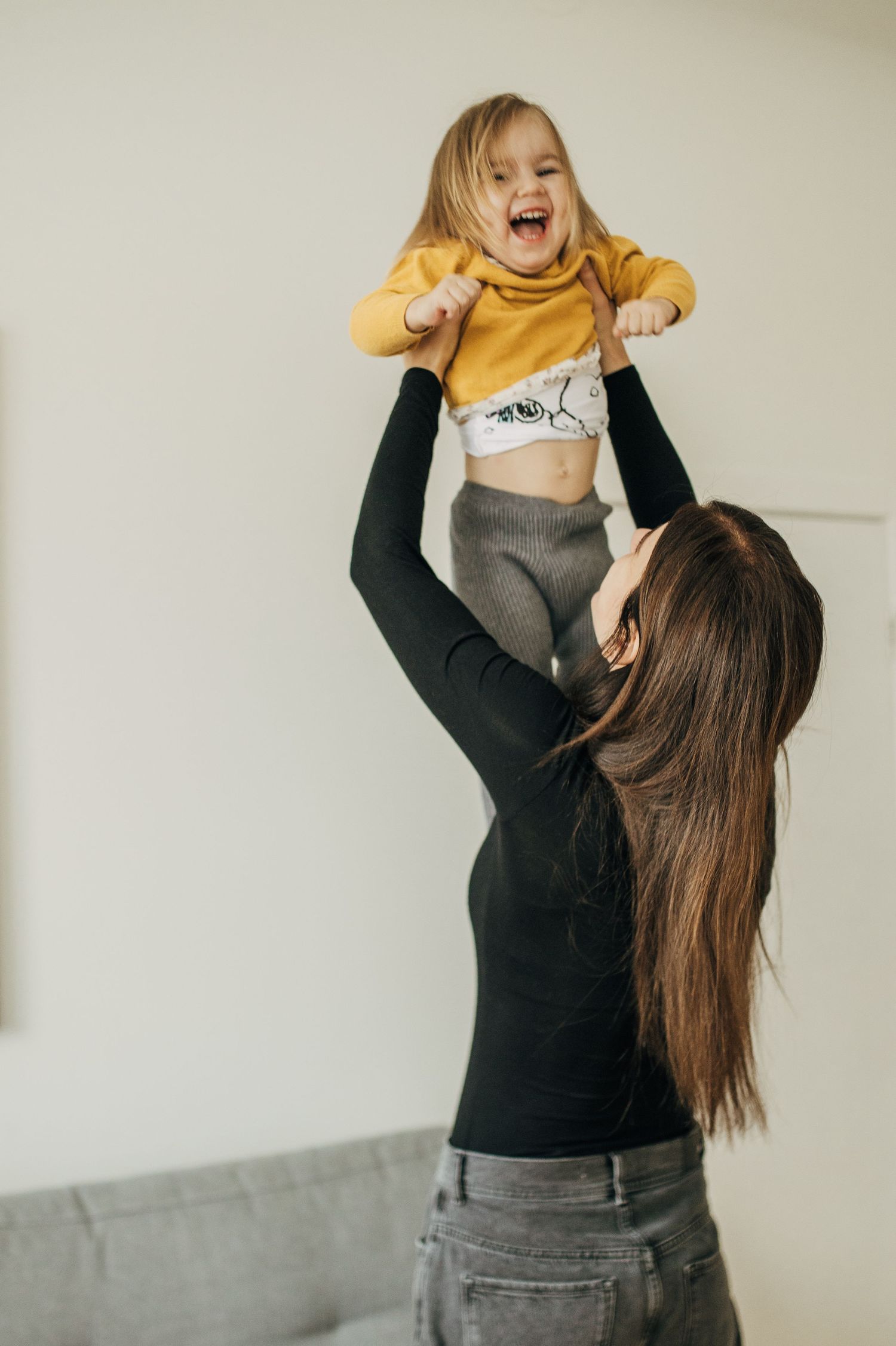 Playful moment of lifting and holding high with expressions of joy and excitement.