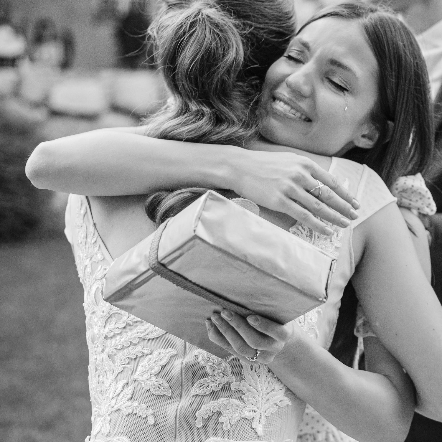 A tender embrace captured in black and white between two people in formal attire.