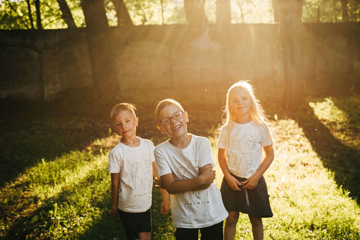 Silhouetted family members walking together in a park during golden hour sunset.
