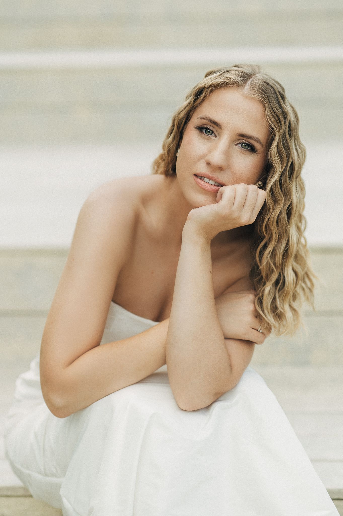 Artistic bridal portrait showing soft expressions and white gown.