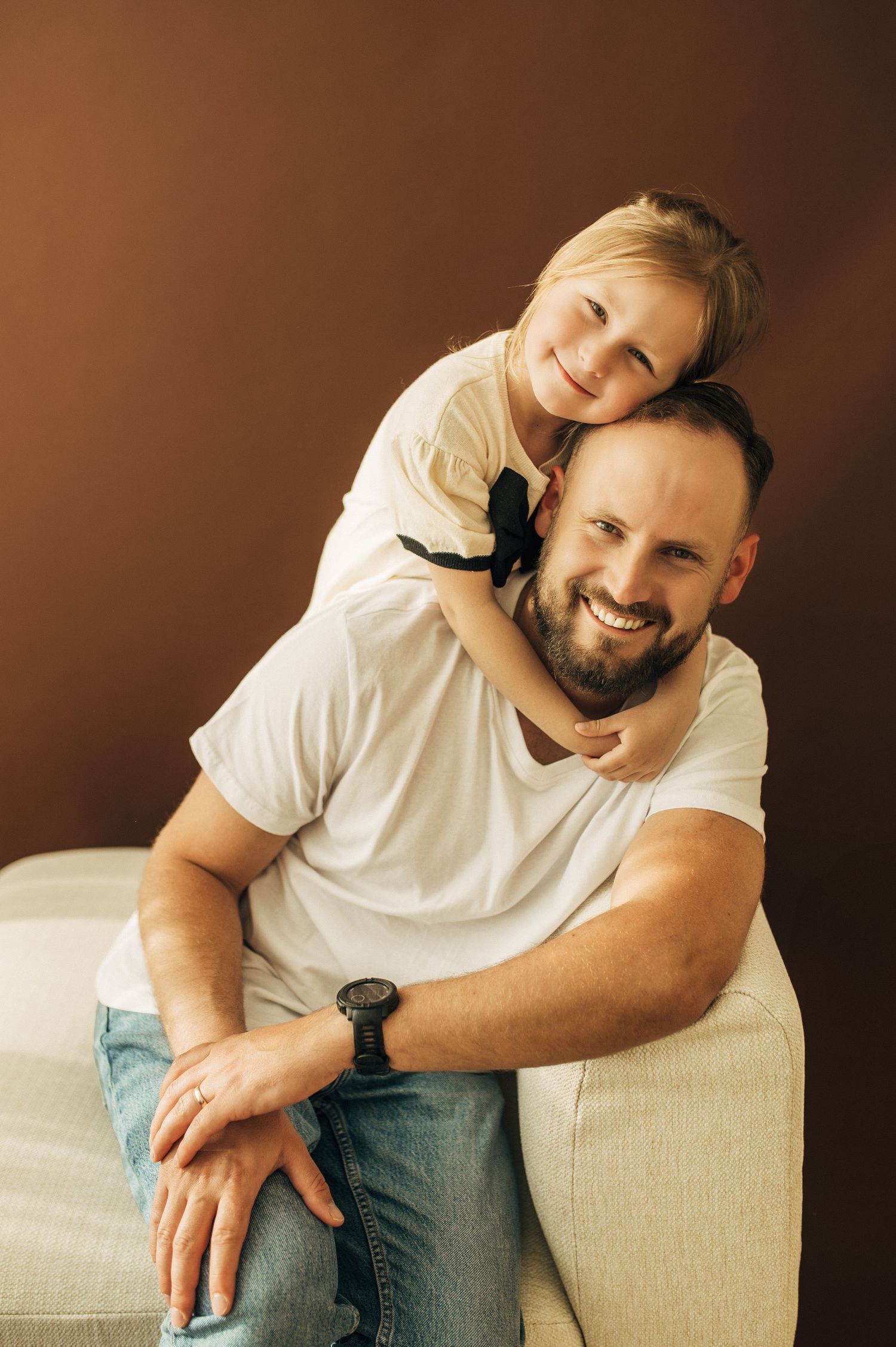 Casual lifestyle portraits on beige couch showing genuine moments of connection.