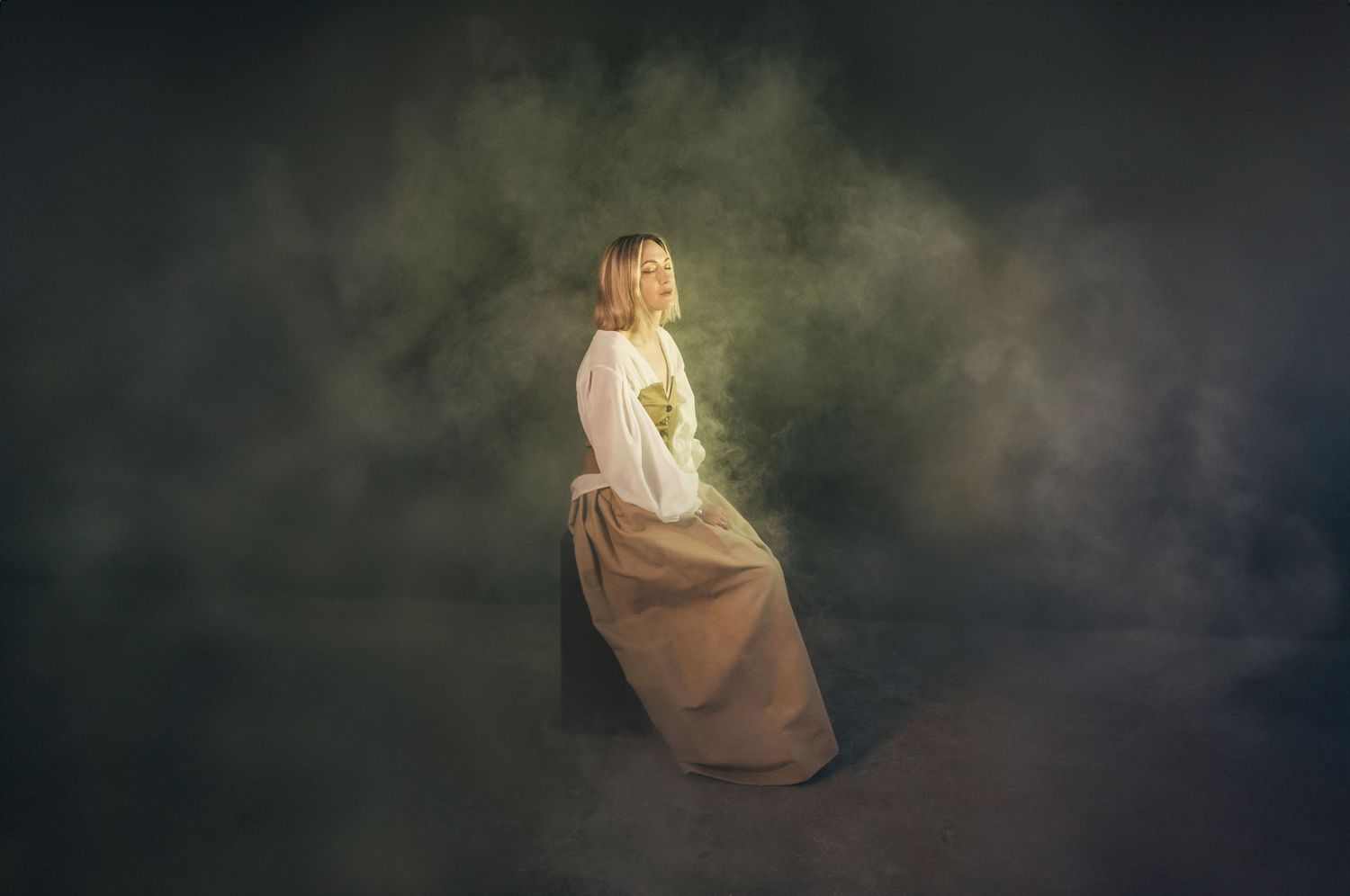 Artistic portraits in dark moody setting with soft backlight creating ethereal atmosphere.