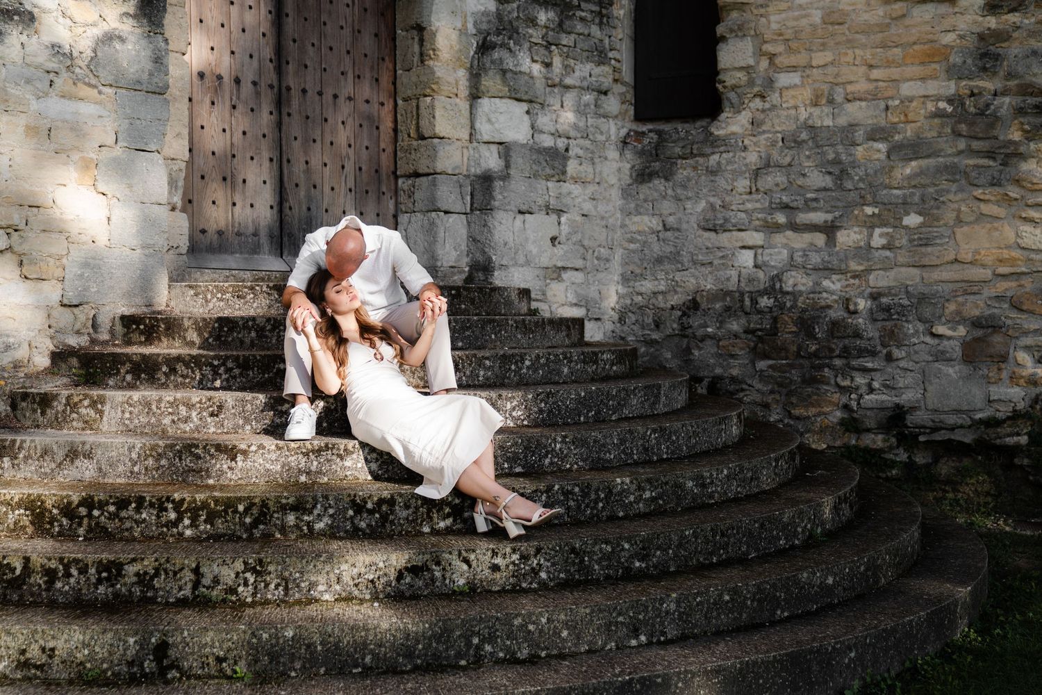 Photo de couple premium, sur des marches d'escalier, lumière naturelle et photo éditorial, photo prise à Bollène.