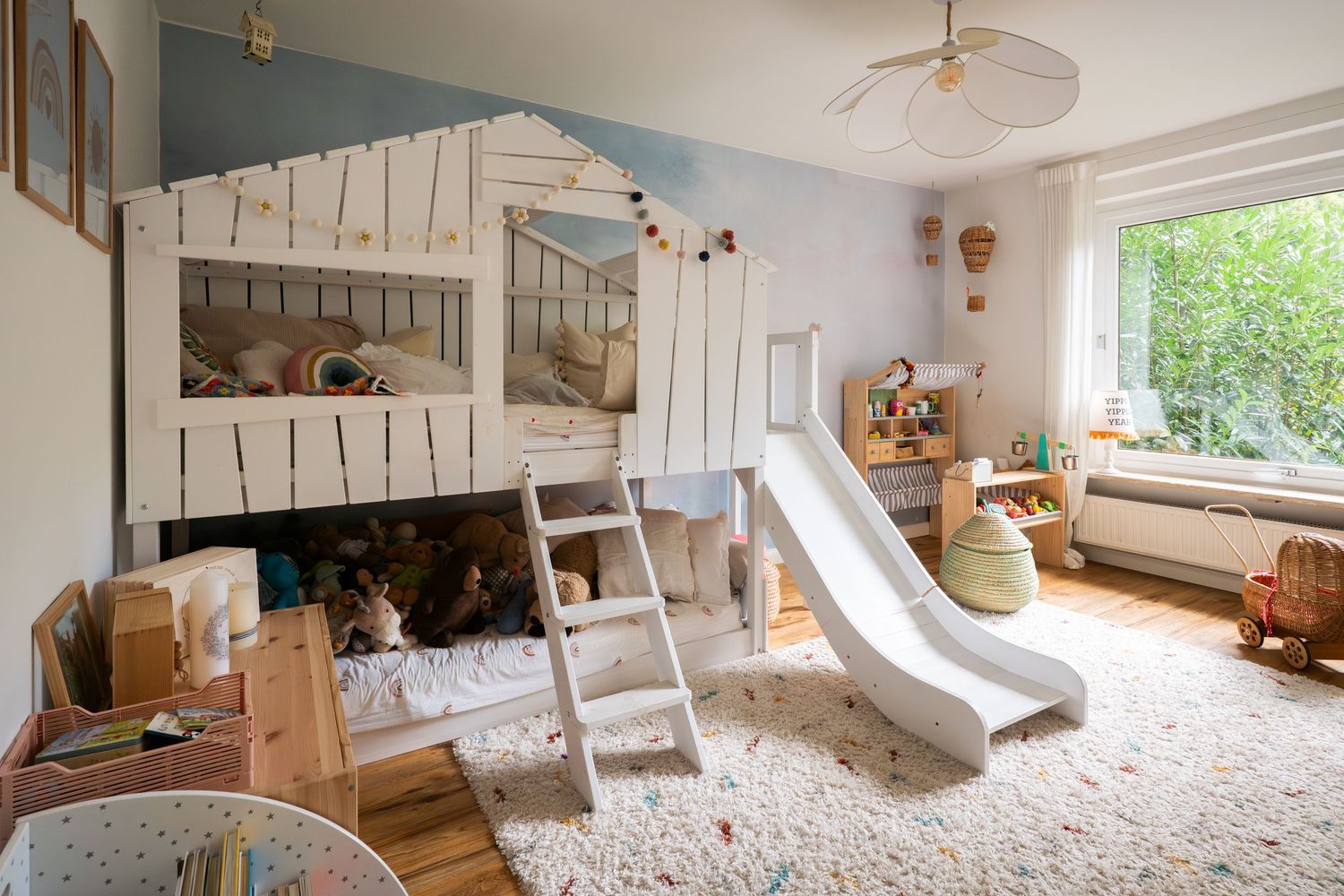 A modern Scandinavian-style nursery with neutral colors, bunk beds, and natural light streaming through large windows.