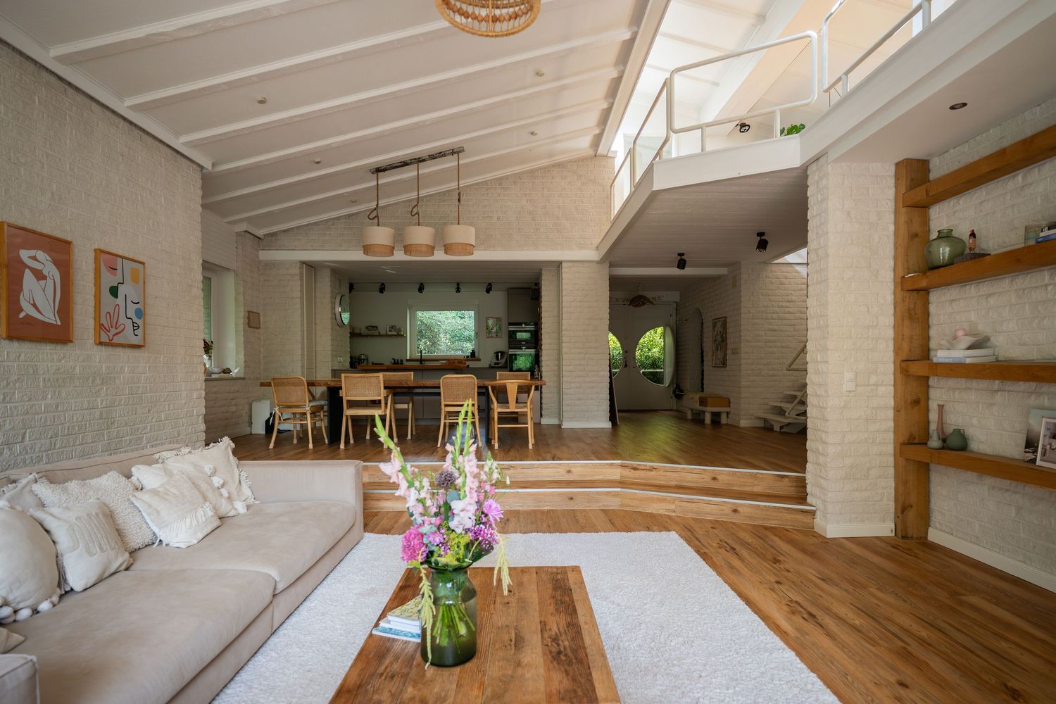 Bright modern yoga studio interior with hardwood floors, white walls, and natural light streaming through large windows.