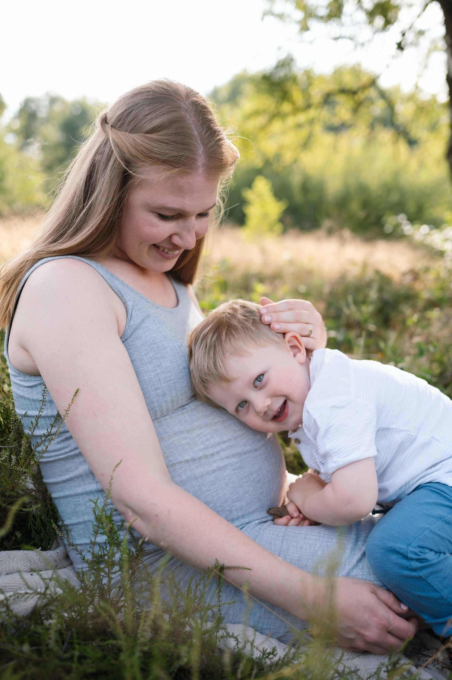 A tender moment of comfort and connection in a sunlit outdoor setting.
