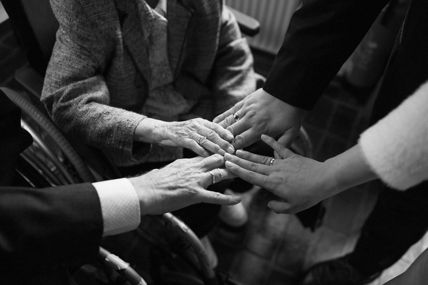Black and white photo series showing hands holding and comforting each other in various tender gestures.