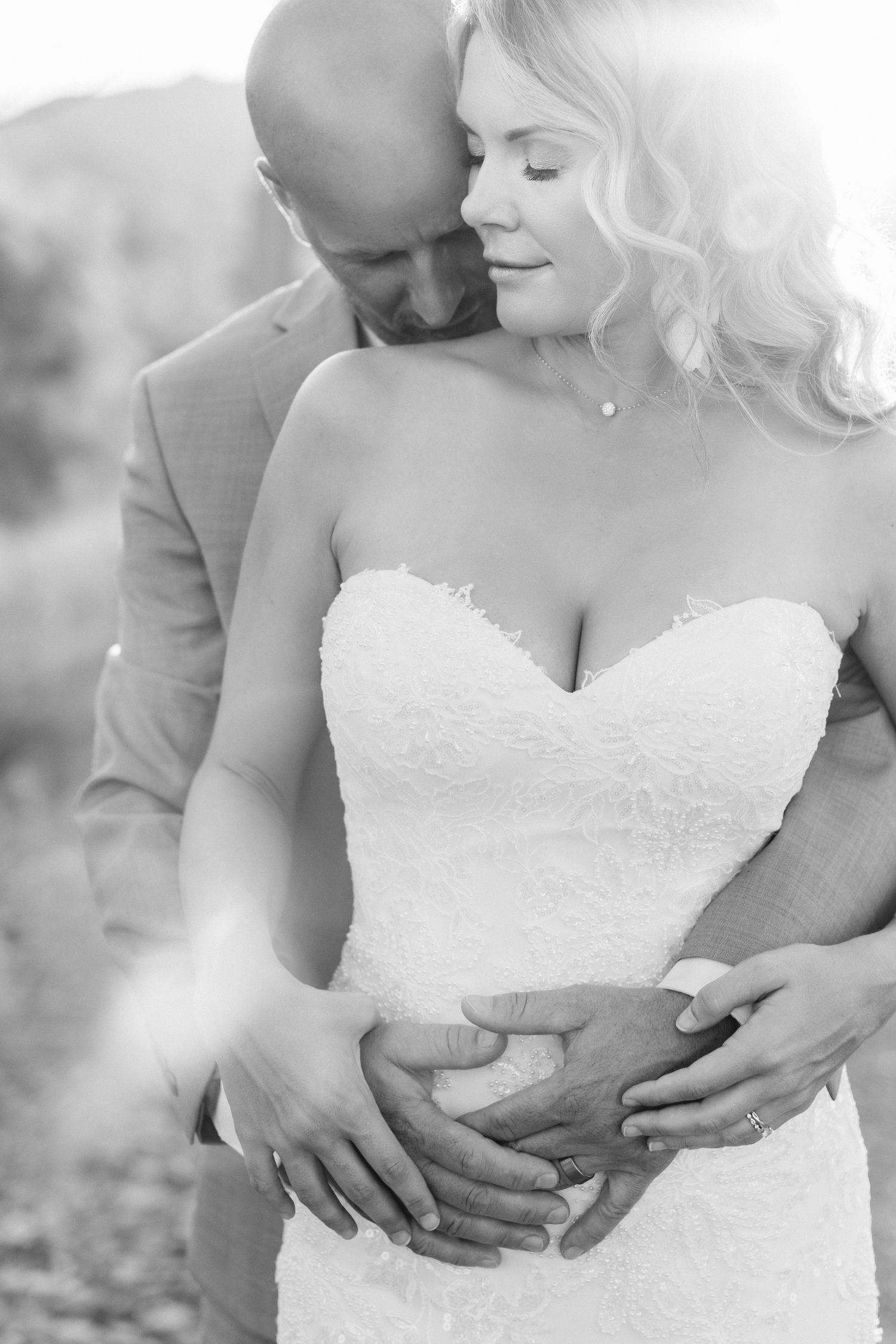 A romantic black and white wedding photo series showing tender moments between newlyweds embracing.