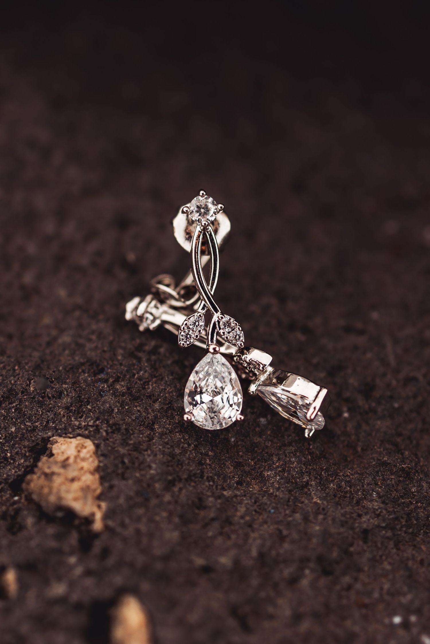 Sparkling diamond stud earrings on dark soil background showing multiple angles and details of the jewelry design.
