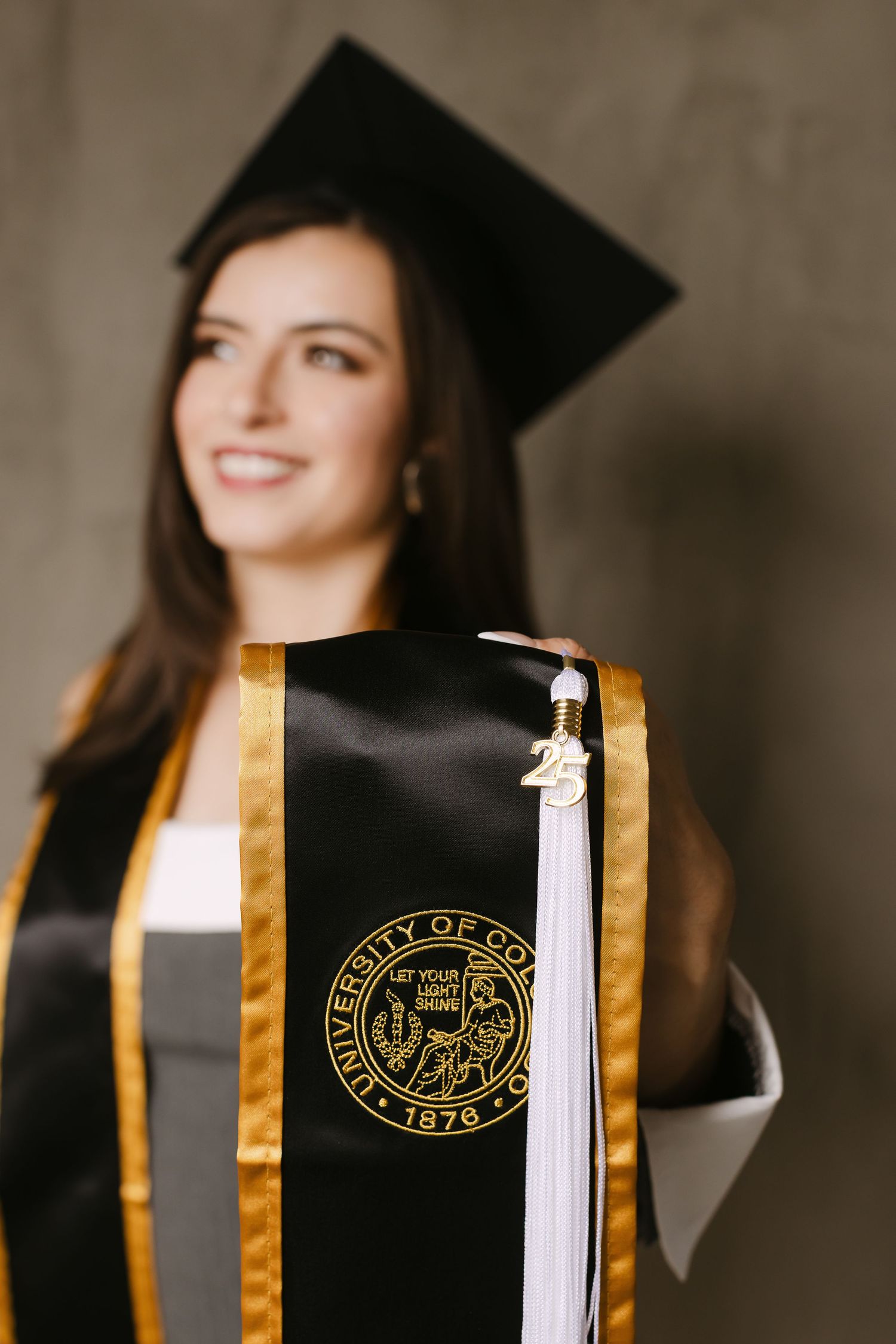 Graduation photos featuring academic regalia with gold trim and university seal.