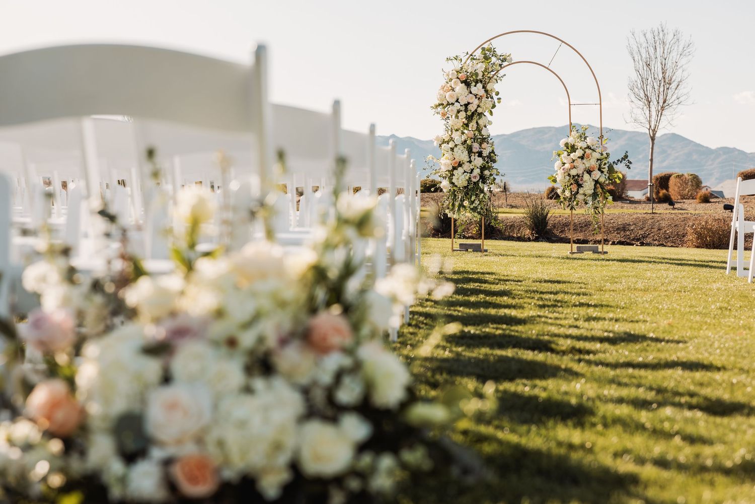 A series of wedding ceremony images showing floral arrangements, outdoor venue setup, and scenic countryside views at sunset.