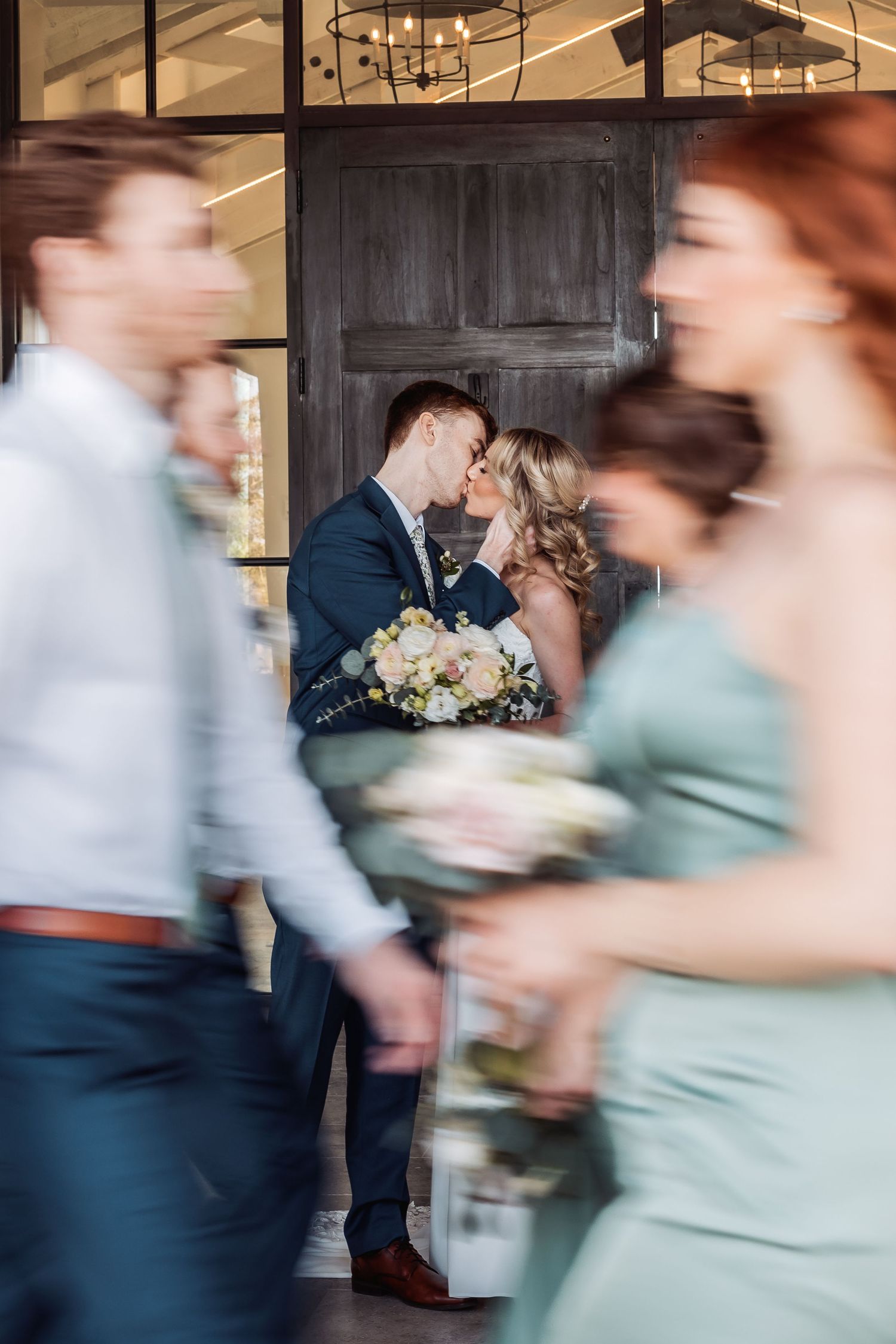 Motion blur captures couples dancing at wedding reception in blush and navy attire.