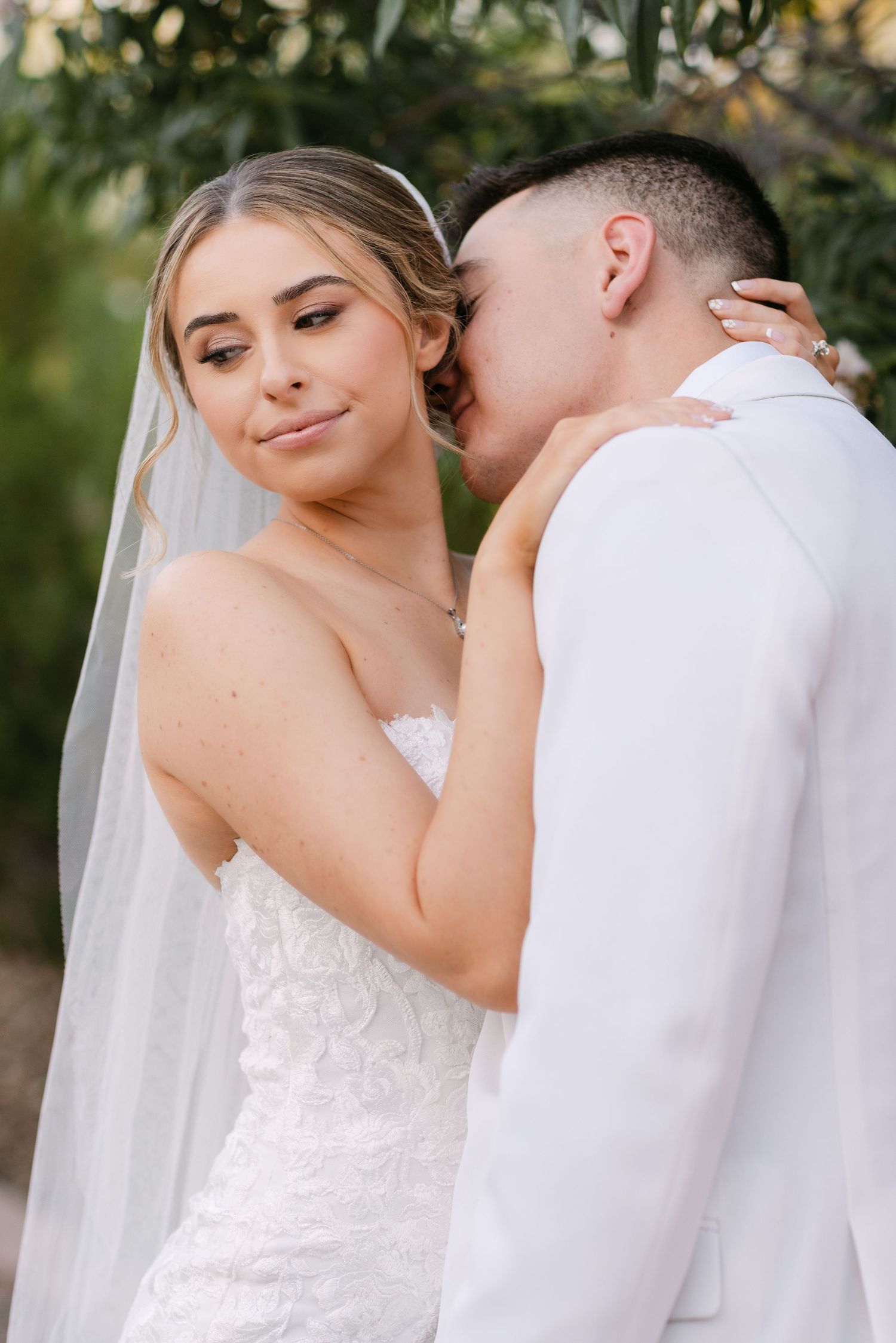 A romantic wedding photo series showing tender moments between newlyweds in an outdoor garden setting.