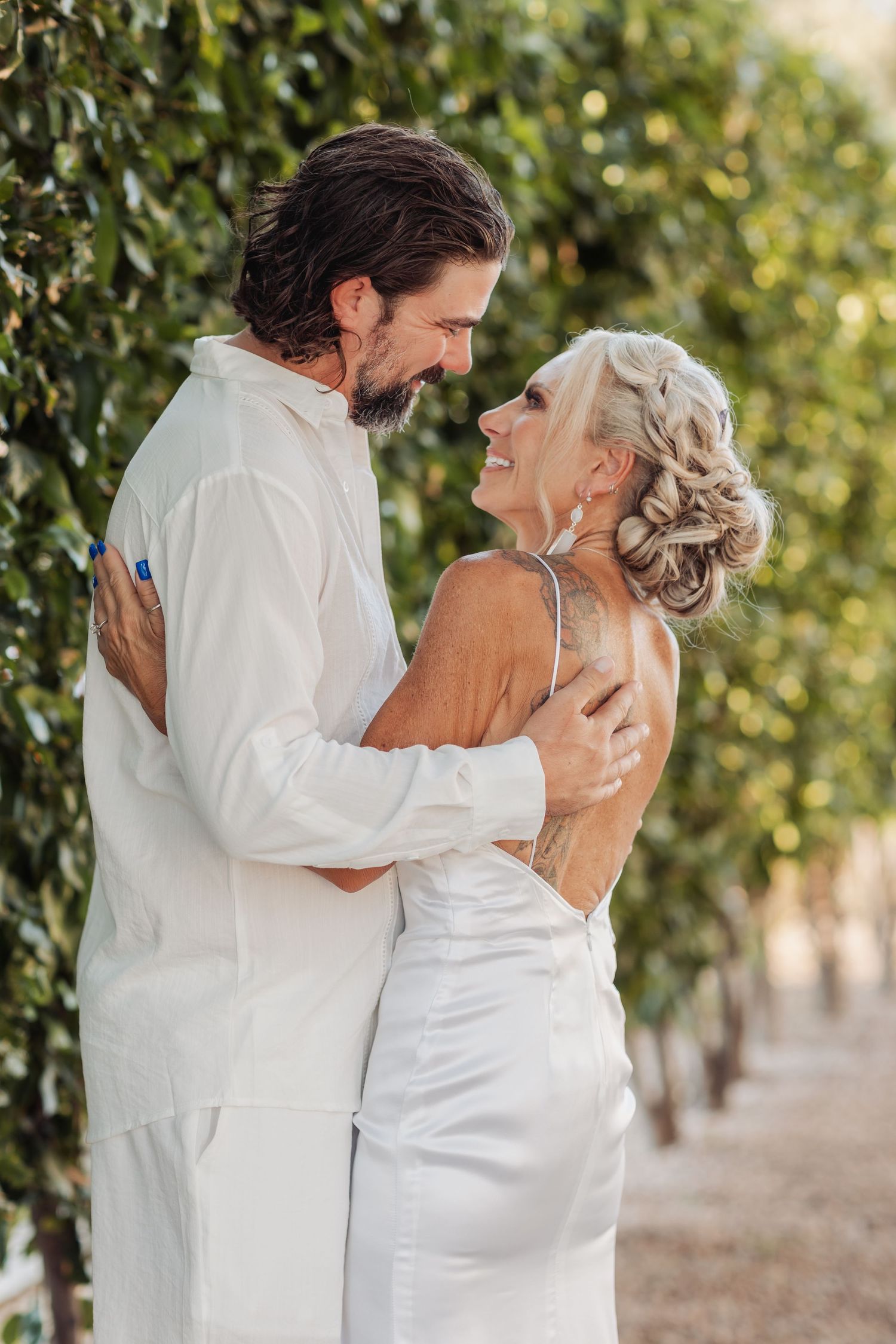Intimate first look wedding photos in a garden setting with white attire.