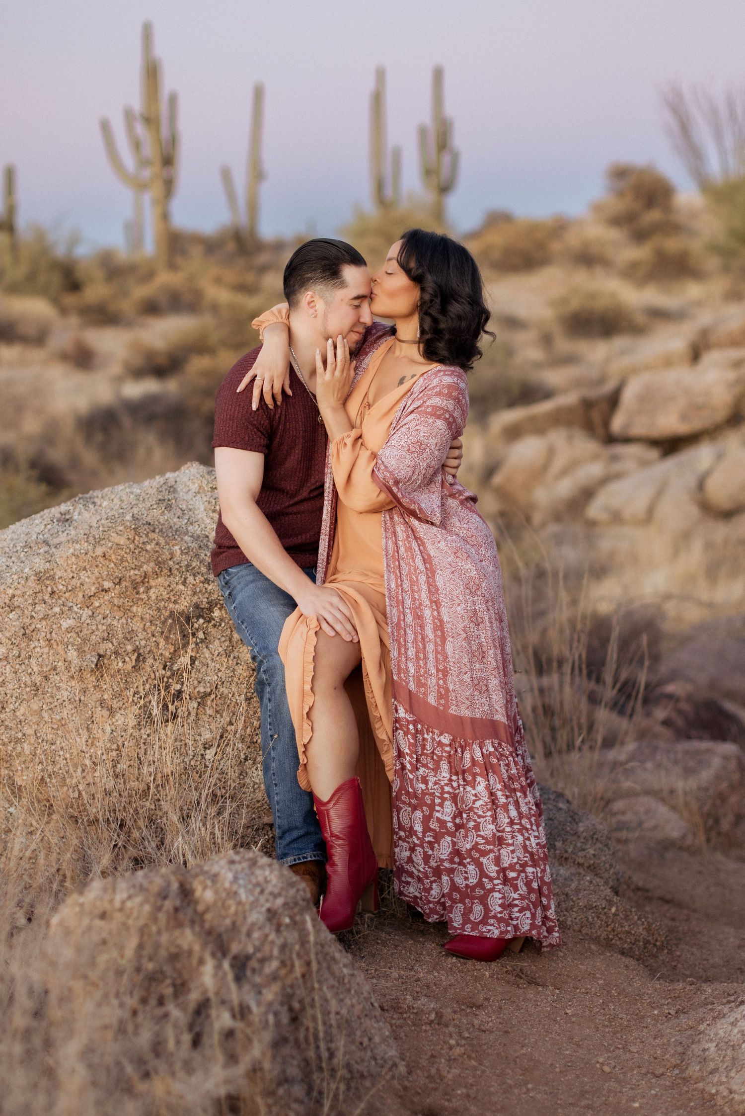 A romantic desert photoshoot with saguaro cacti in the background as the sun sets over the Arizona landscape.