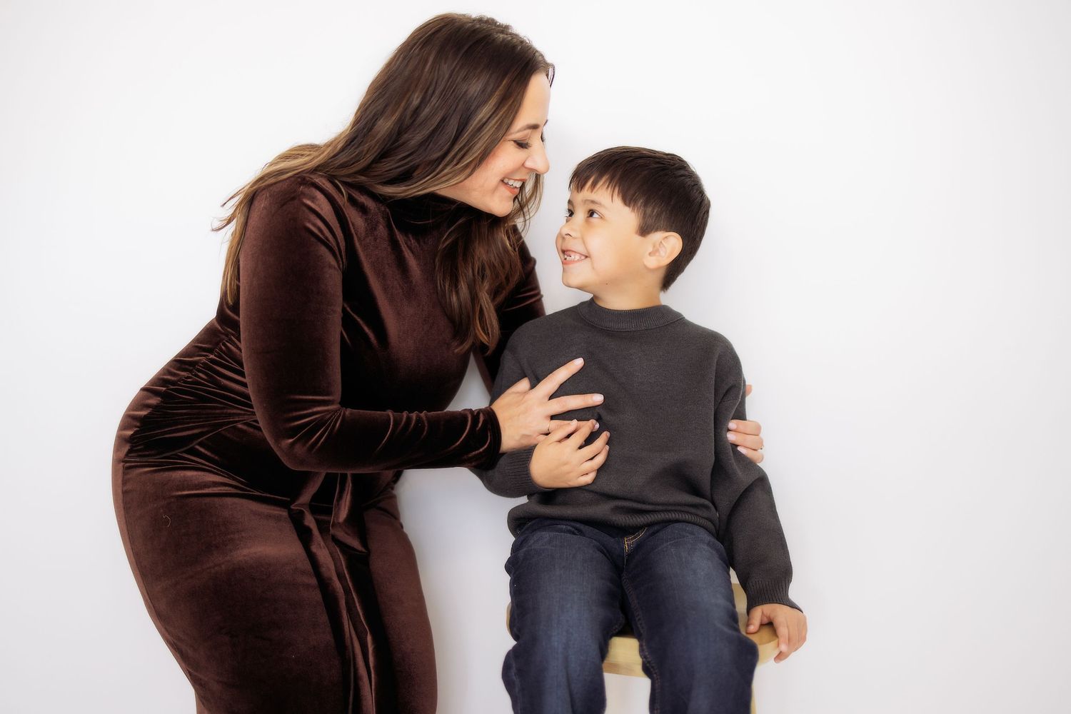 Woman consoling upset child sitting on chair in four progressive emotional stages against white background.