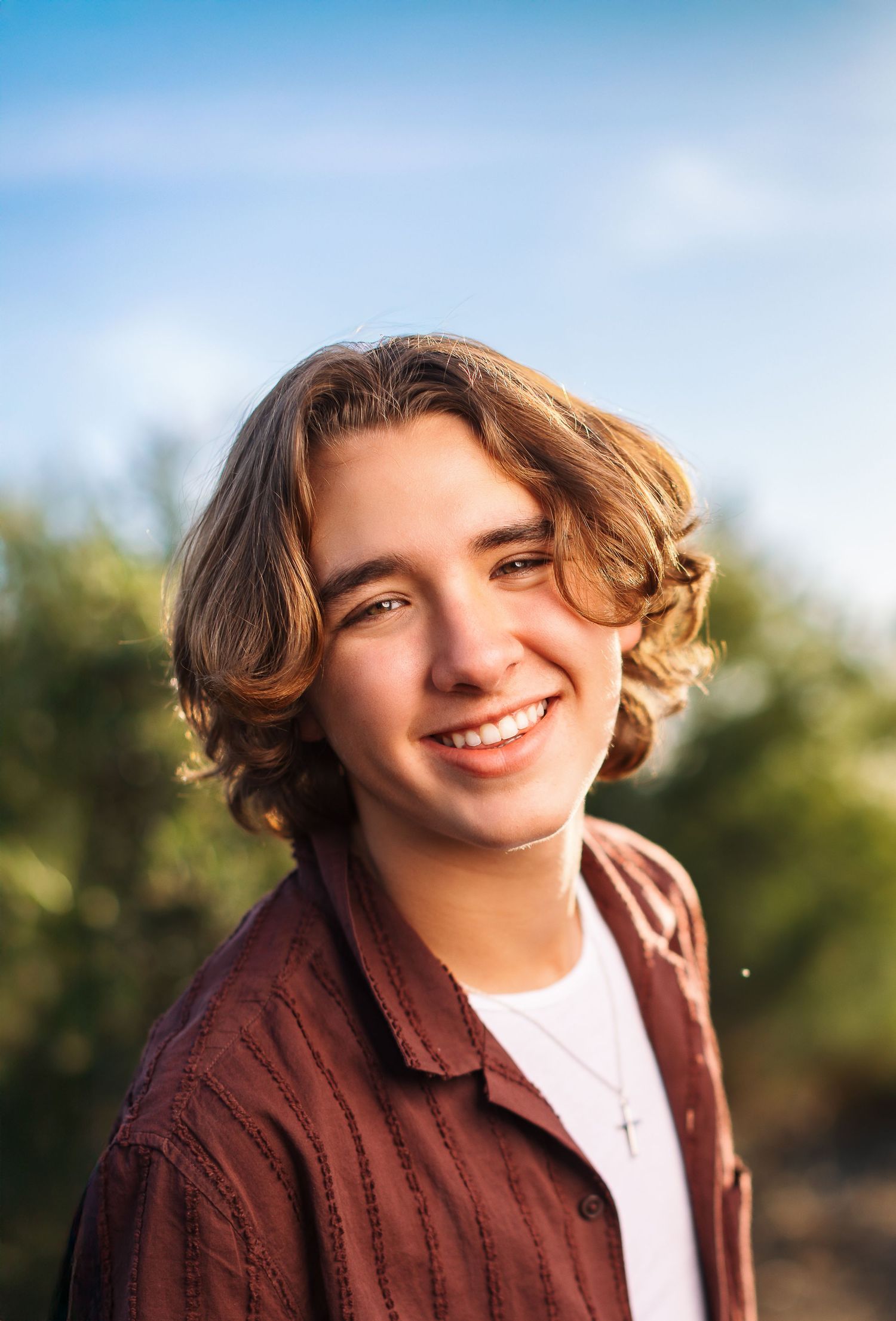 A series of warm, outdoor portrait photos featuring a person in a burgundy jacket and white shirt against a blurred natural background.
