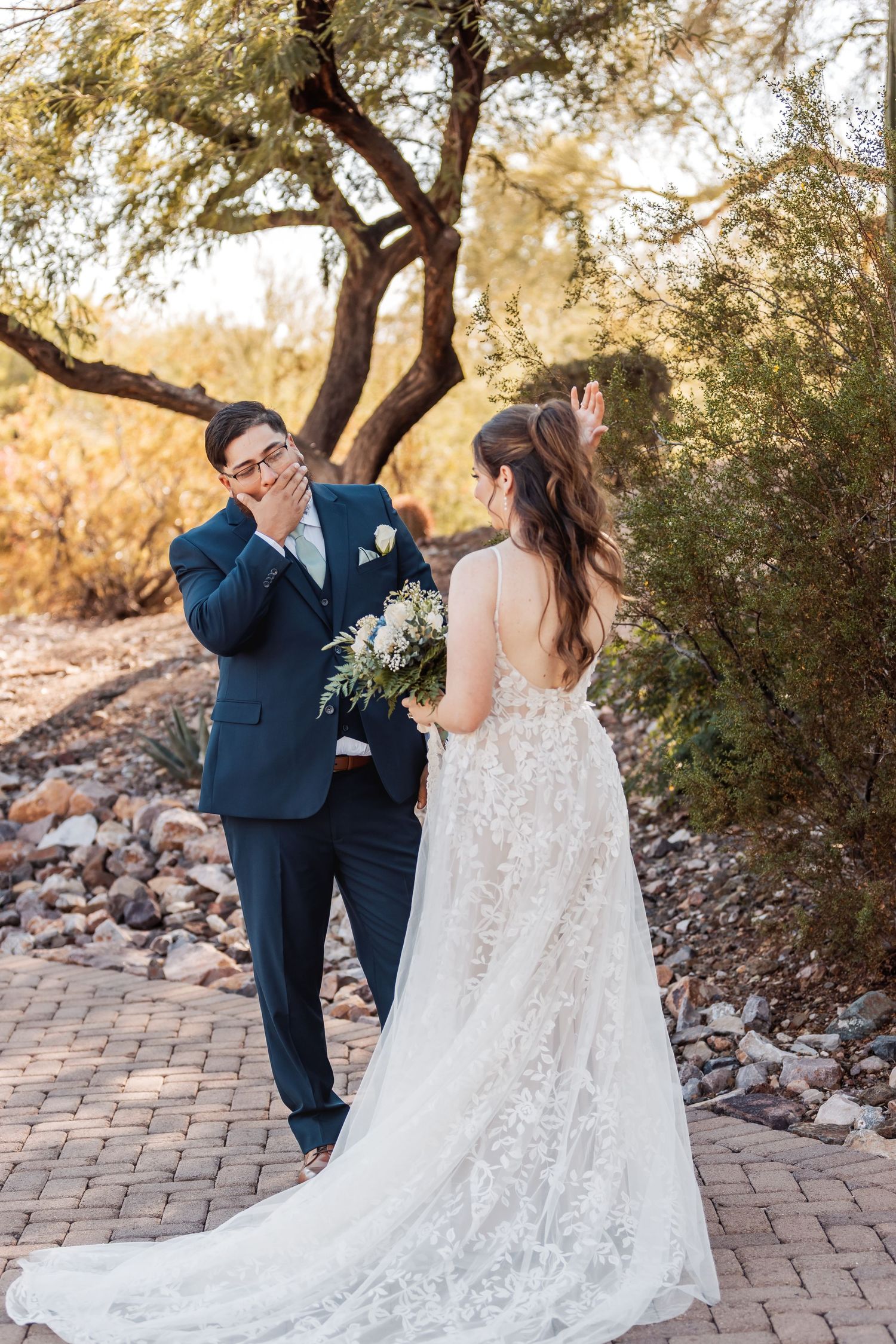 Bride and groom having a joyful reaction during their first look in a desert garden setting.