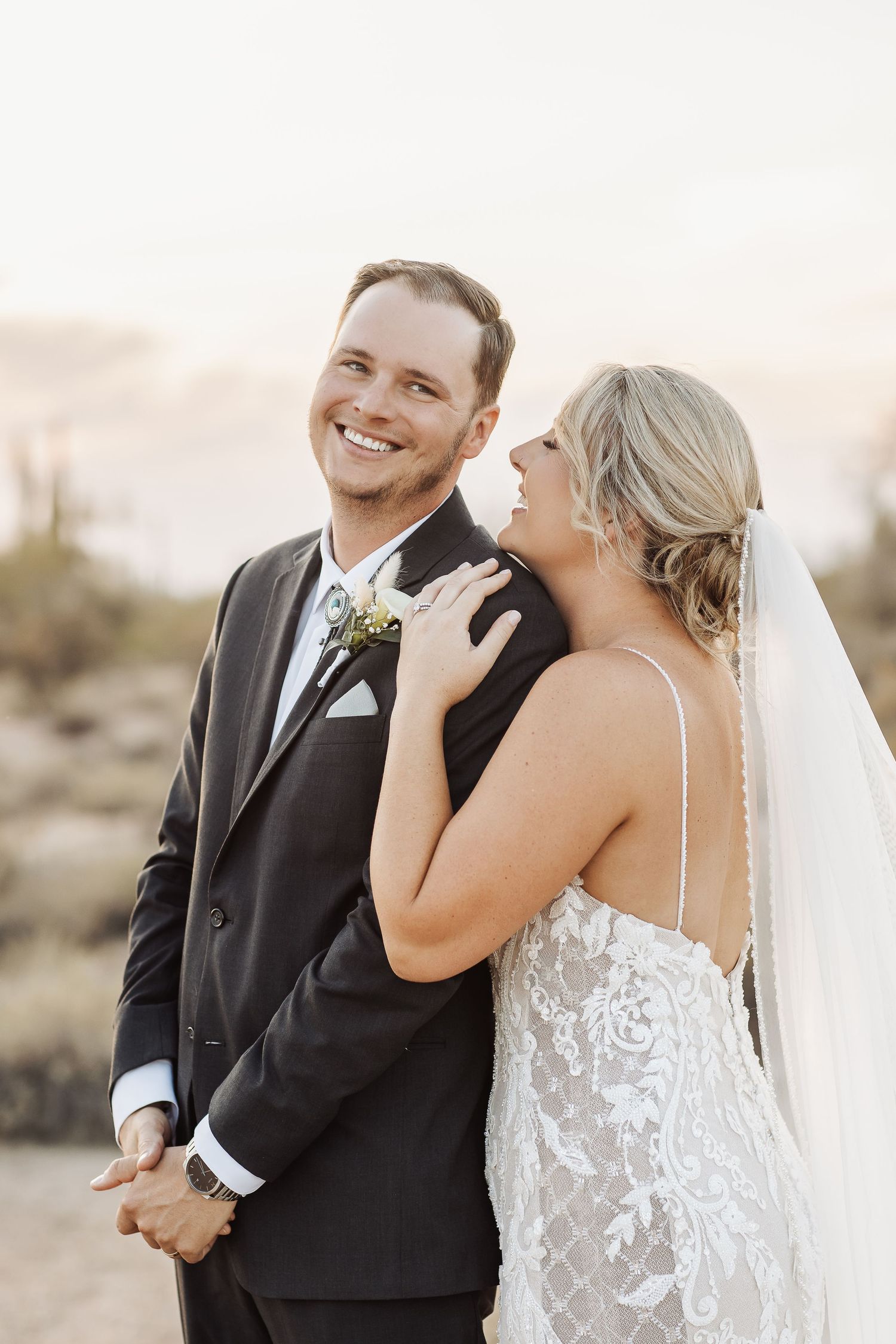 Candid wedding portraits capturing joyful moments between newlyweds in desert setting.