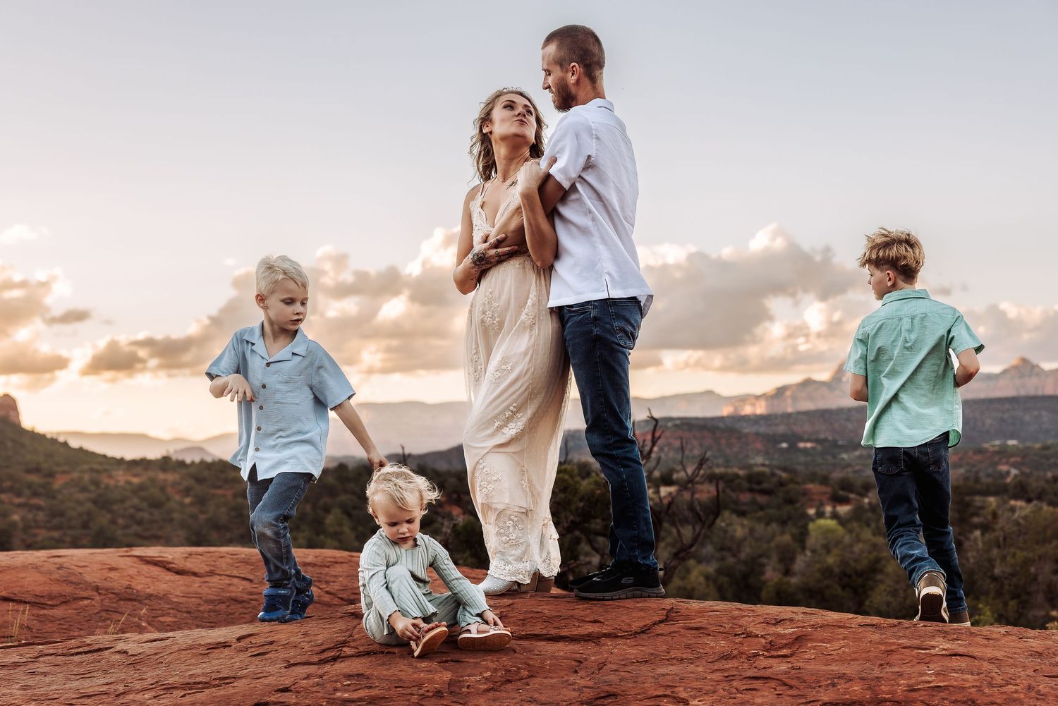 Family enjoying sunset views together at scenic desert overlook in Arches National Park.