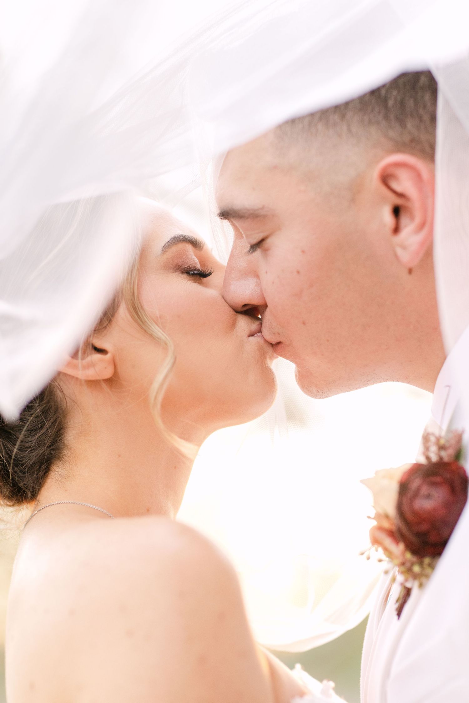 Intimate close-up wedding photos showing tender moments between the newlyweds in soft white lighting.