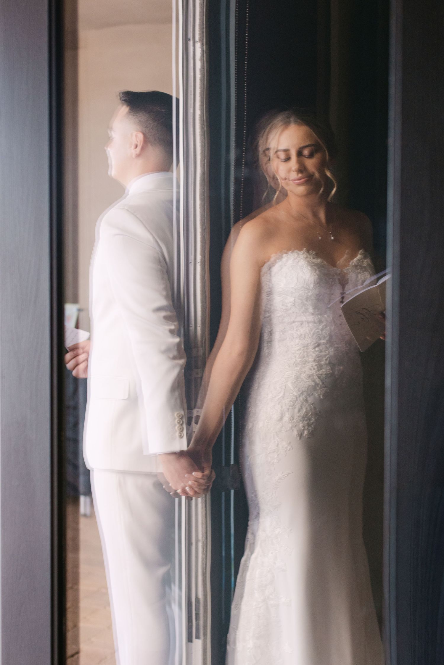 A series of four artistic wedding photos showing a couple in white attire through frosted glass panels.