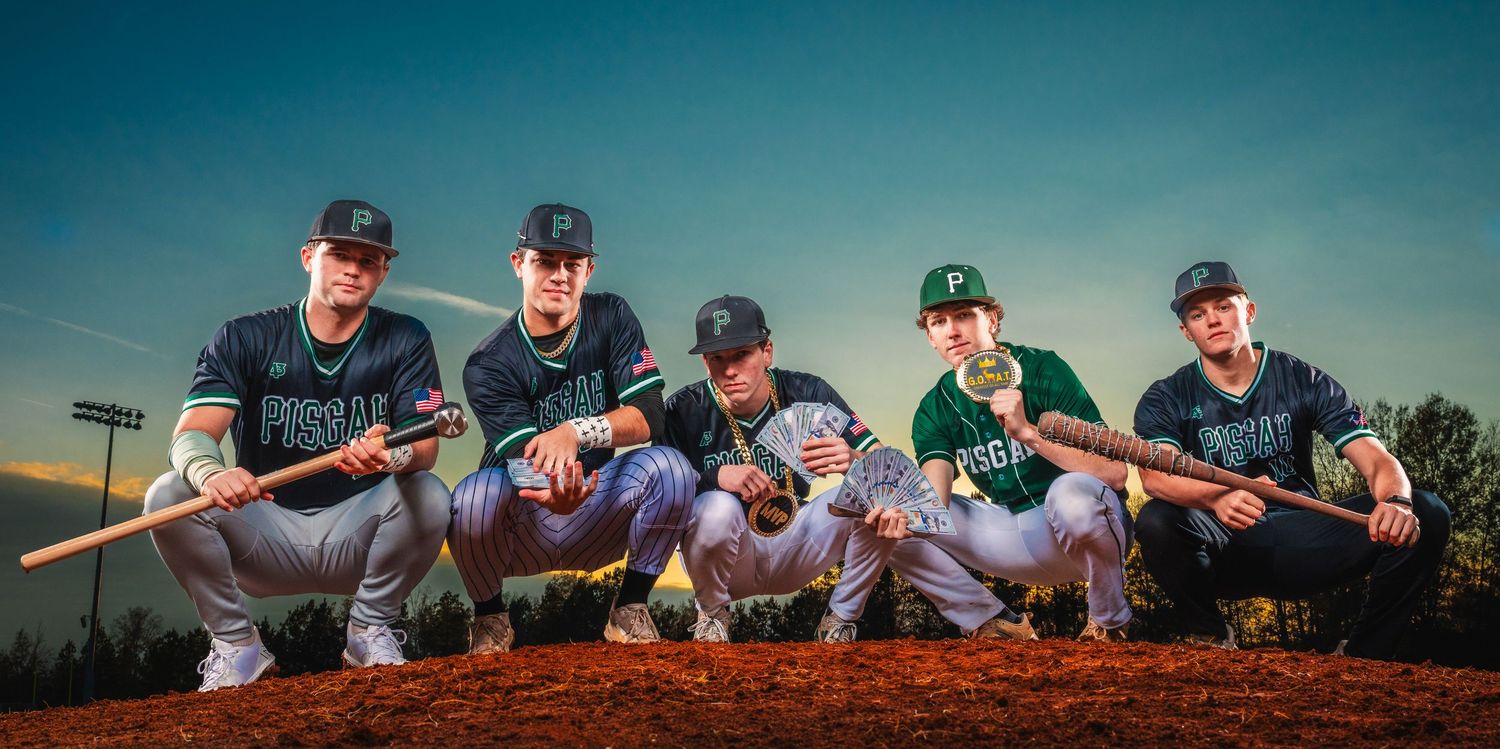 Five baseball players posing with bats at sunset on a field.