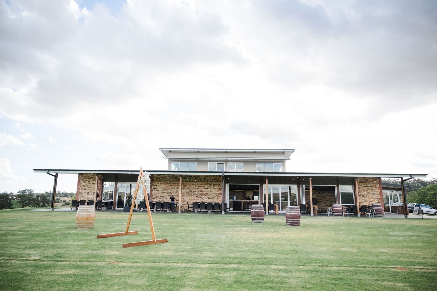 Archery targets lined up on a grassy field with a building visible in the background.