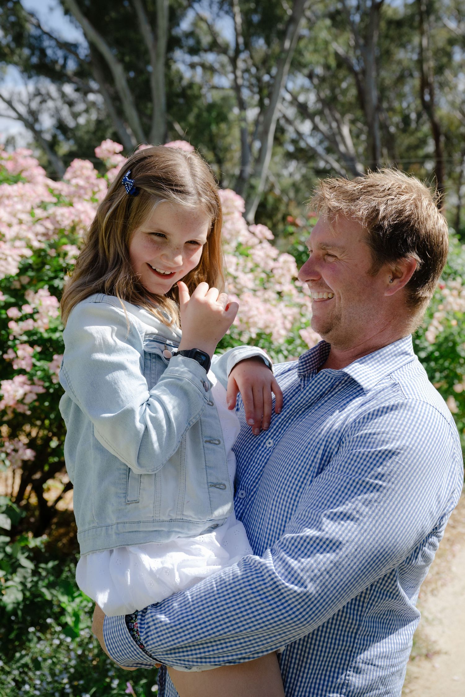 A series of candid moments showing a parent and child playing and laughing together outdoors in a garden setting.