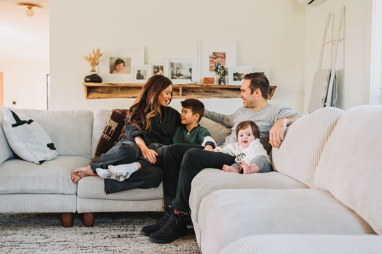 Family relaxing together on a comfortable grey sectional sofa in a bright living room.