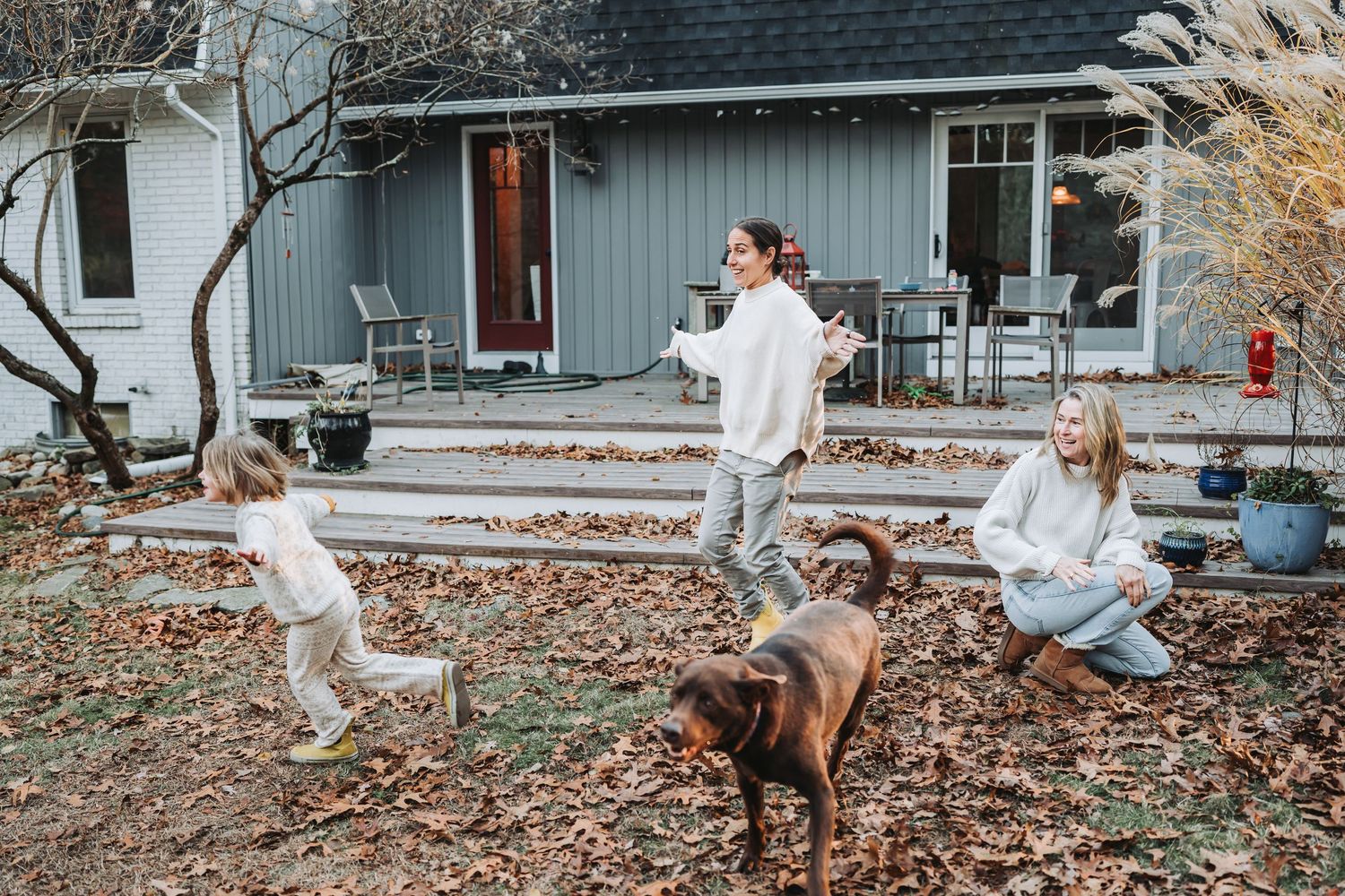 A collage showing playful moments outside a house with a dog jumping and running through fallen autumn leaves.