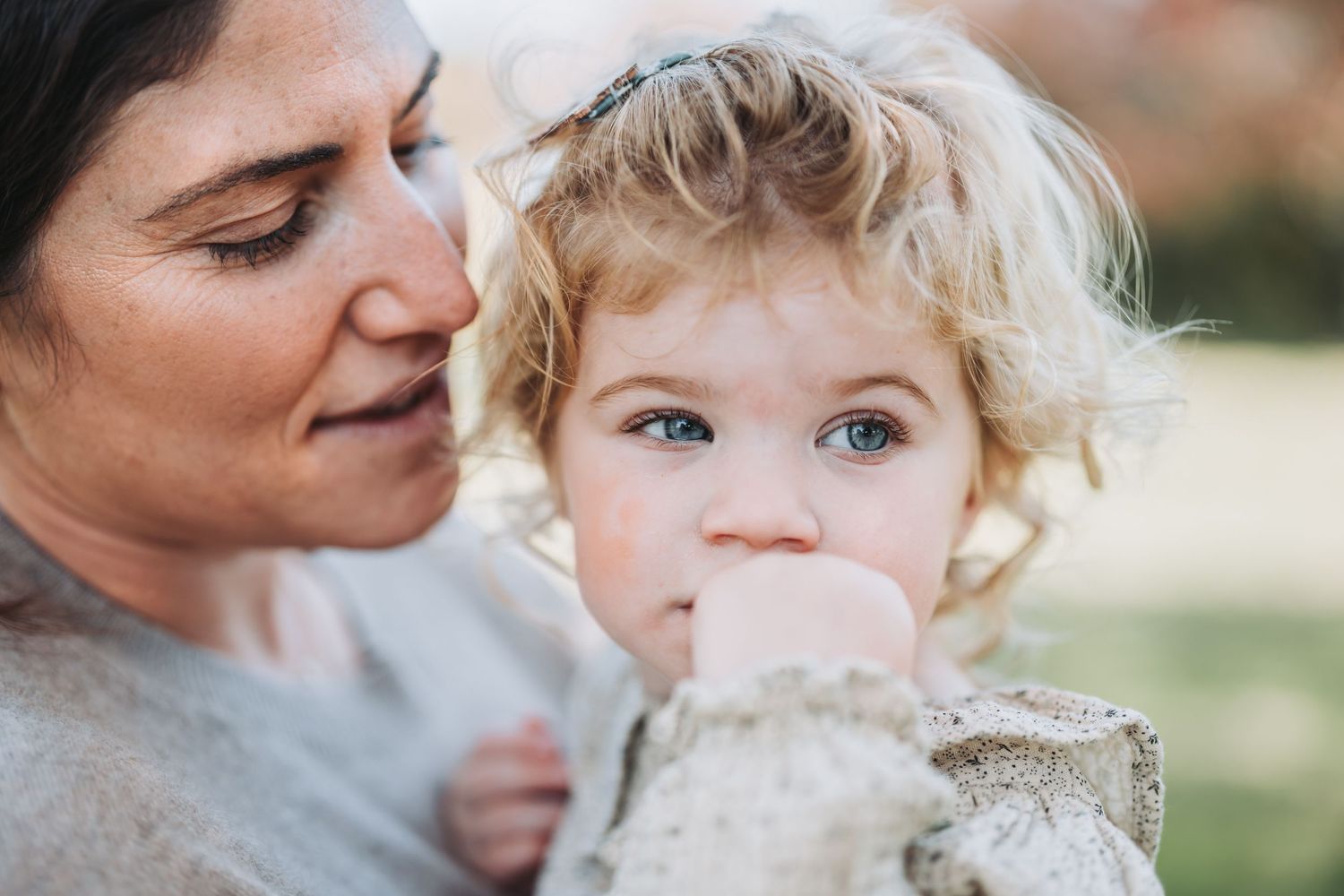 Close-up tender moment captured outdoors in natural lighting.