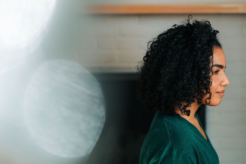 A person with curly dark hair and glasses turns their head in a sequence of profile shots against a blurred background.