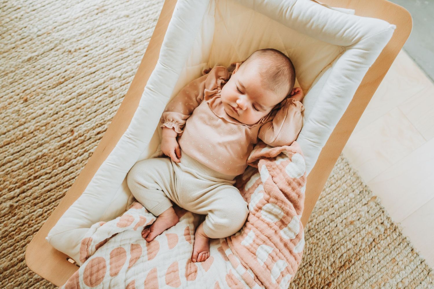 A montage of a newborn baby sleeping peacefully on textured blankets in soft natural light.