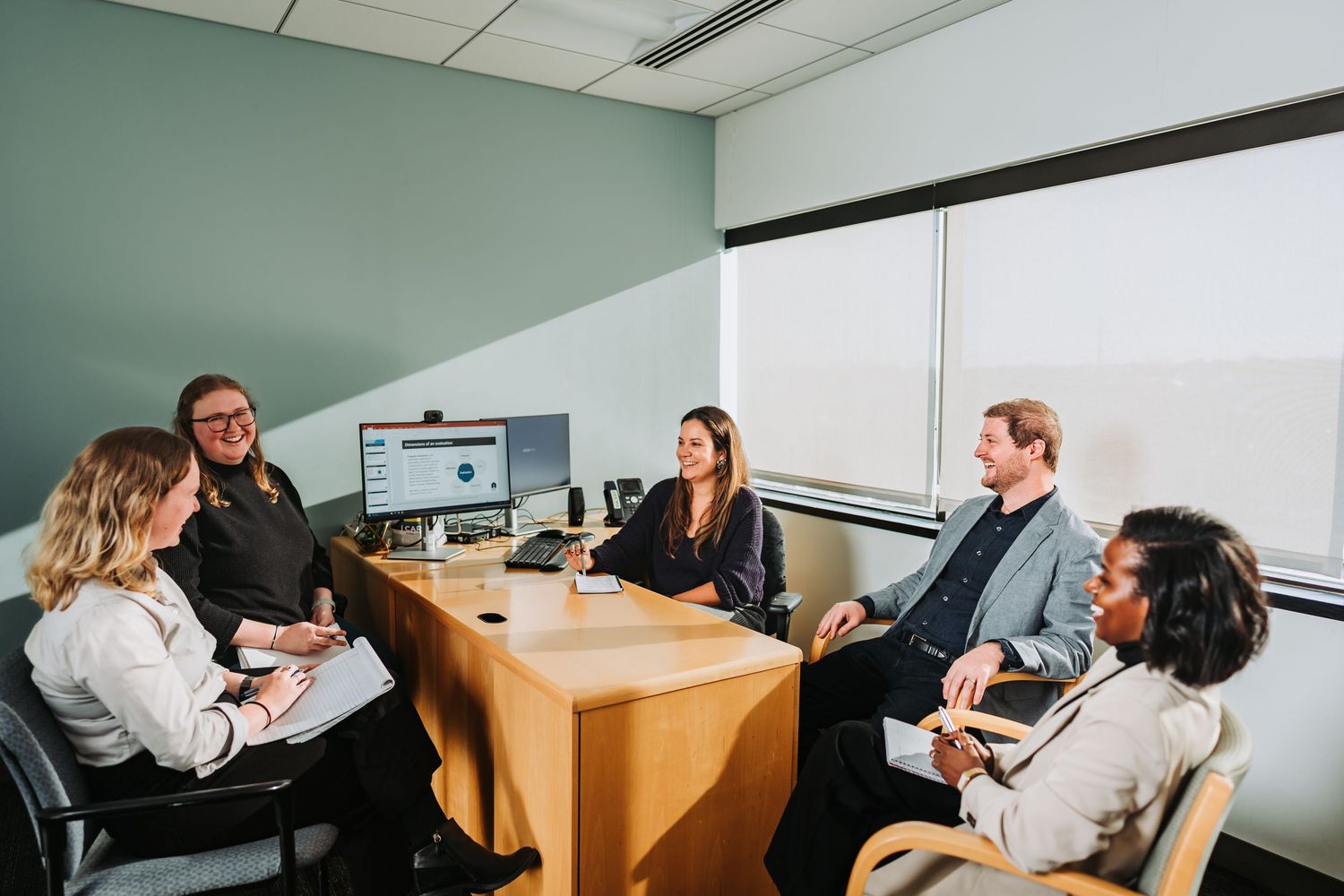 Business team collaborates in modern office meeting room during a professional discussion.