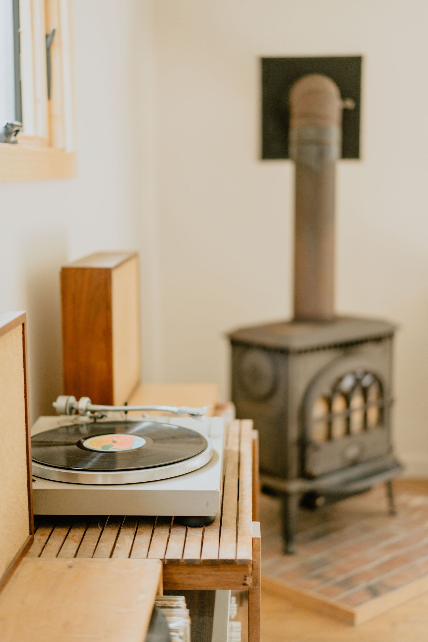 Vintage record player turntable setup with wooden furniture in a minimalist interior setting.