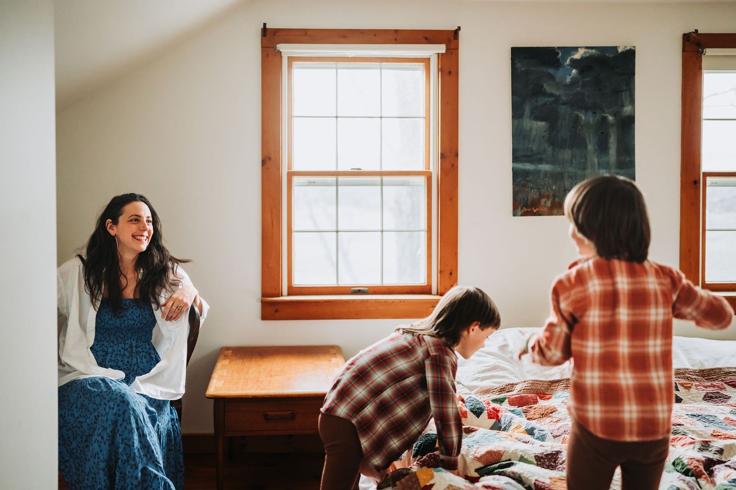 A family gathers together around a wooden dining table for a shared meal in a bright, sunlit home.